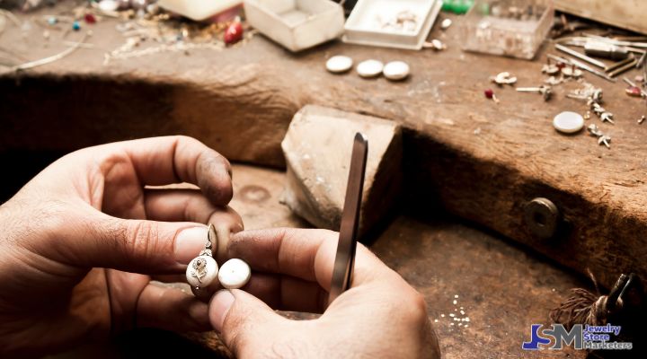 Jeweler repairing a silver pendant at a workbench